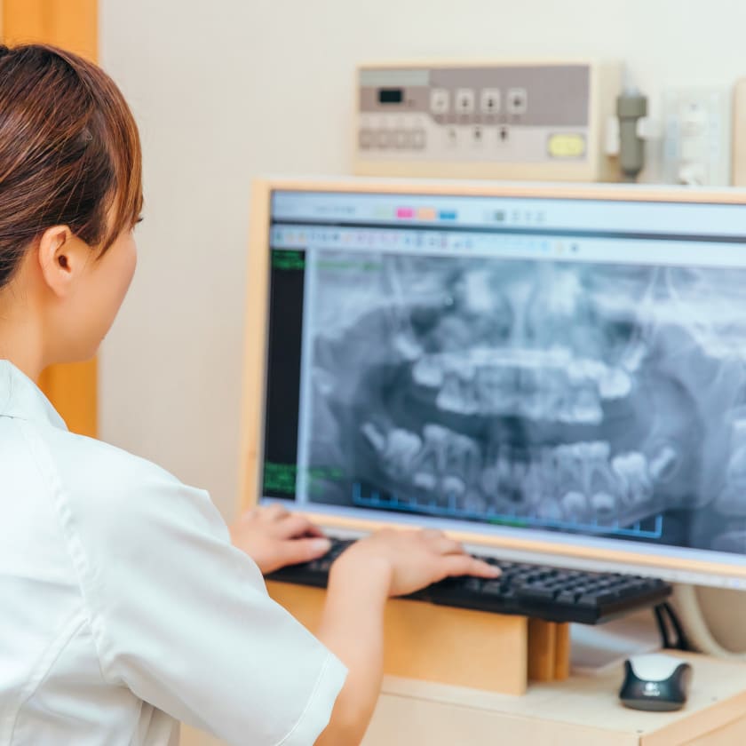 A dentist looking at dental X rays | Kokua Smiles