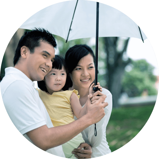 A happy family of three under an umbrella | Kokua Smiles